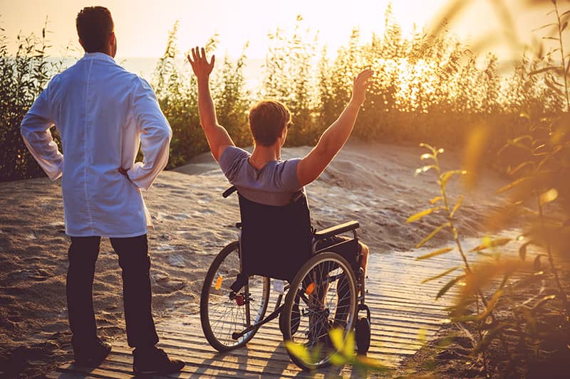 provider-help-happy-man-in-wheelchair-with-male-nurse